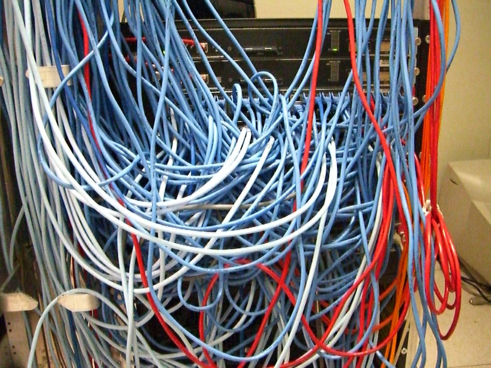 Rack com cabos de rede emaranhados, sem identificação